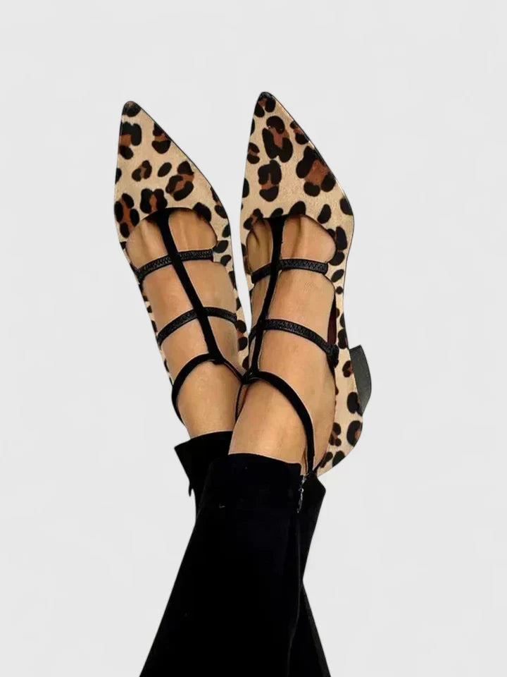A woman standing gracefully in low wide-fit comfort heels with a cushioned footbed.