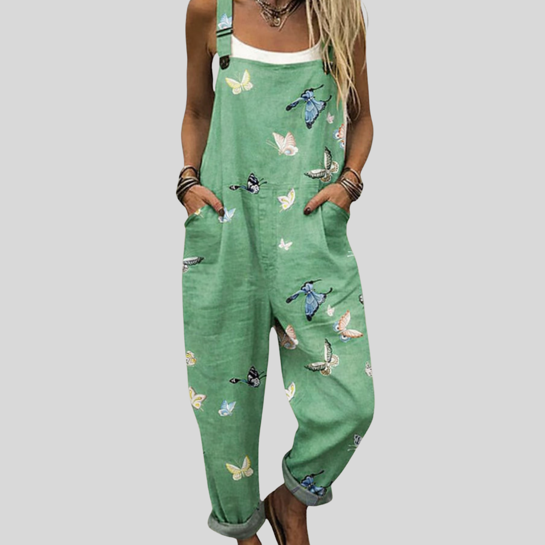 Fresh green dungarees with a scattered print of cream and blue butterflies and long-tailed birds, adjustable shoulder straps and side pockets.