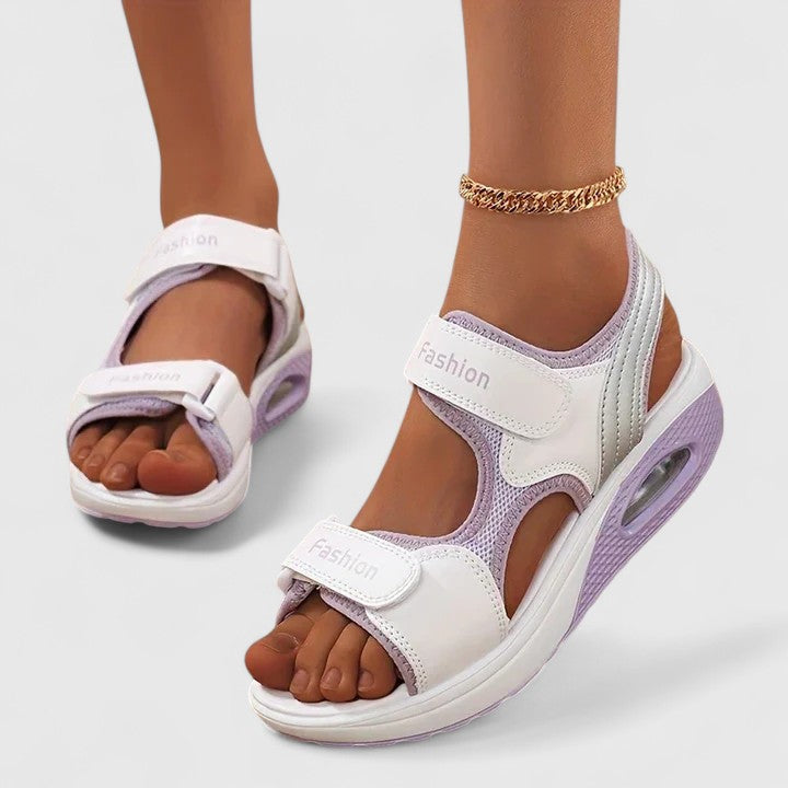 A woman in white sandals with a lilac trim walking comfortably, feet supported and light.