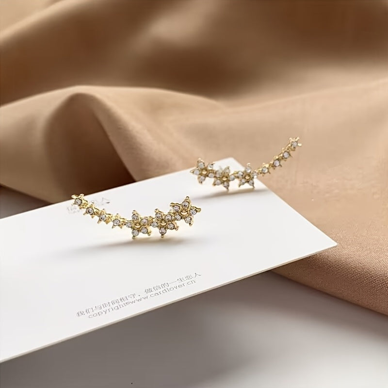 Rose gold floral crawler earrings with delicate sparkling floral motif following the curve of the ear