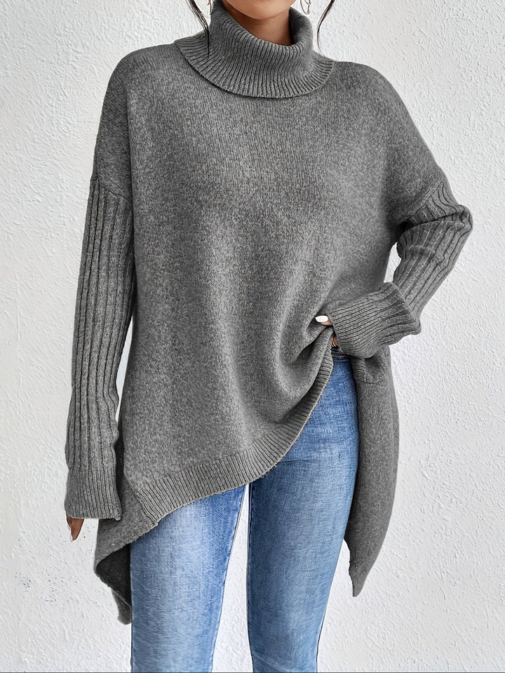 A woman wearing a stand-collar jumper with a chic asymmetric drape, warm and polished.
