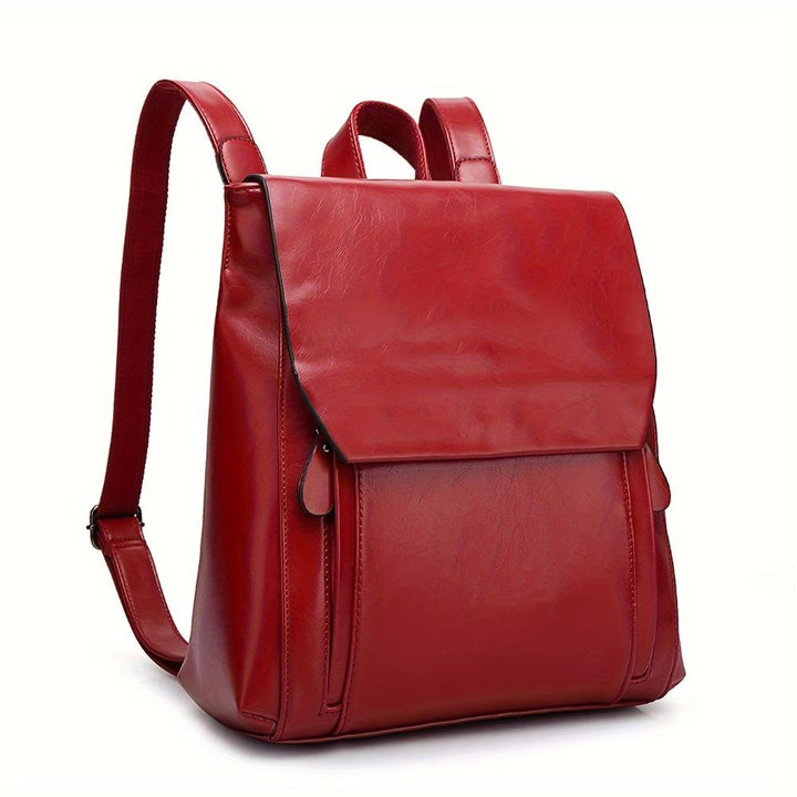 A woman wearing a padded vintage-style backpack over both shoulders while walking through the city.