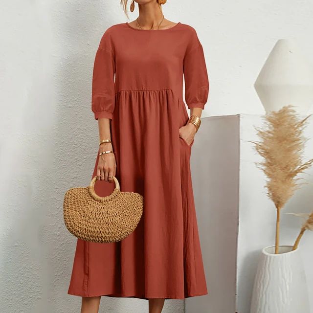 A woman wearing the Sheila fitted waist midi dress with three-quarter sleeves and a flowing skirt.