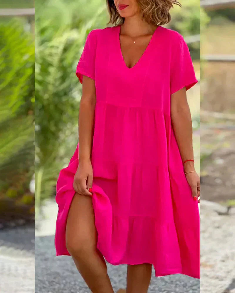 Woman wearing the Veronica™ V-neck summer dress with a soft layered skirt, strolling on a sunny afternoon.