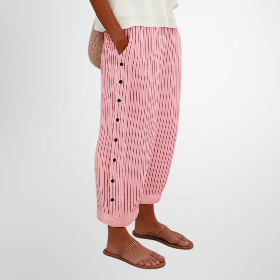 A woman wearing elegant everyday trousers in a fine blue stripe with a wide cut and side buttons.