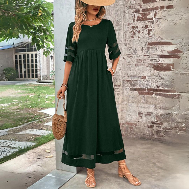 Woman wearing the Winifred™ empire waist midi dress with a flowing skirt and round neckline at a family gathering.