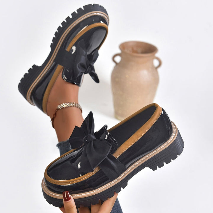 Bold loafers with a high-shine finish and statement bow detail, available in green, beige, black, brown and burgundy