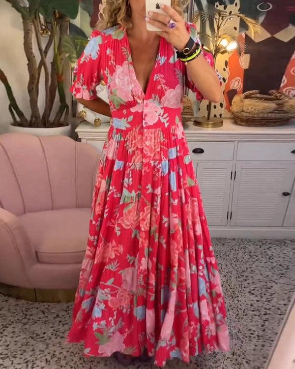 A woman wearing the Josephine bold floral maxi dress with a flowing full-length skirt at a garden gathering.