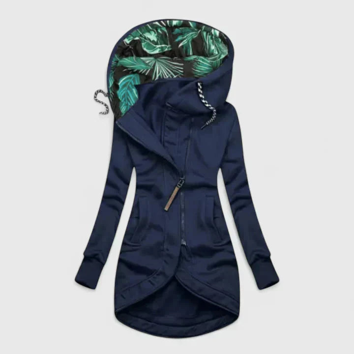A woman wearing a weatherproof jacket, standing outdoors on a rainy day