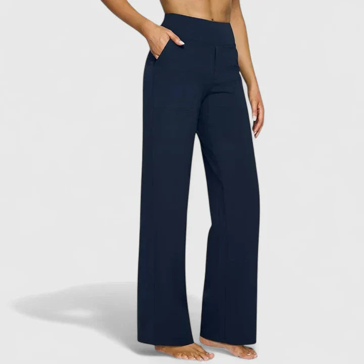 A woman in tailored trousers styled with a simple top for an elegant, comfortable everyday look.