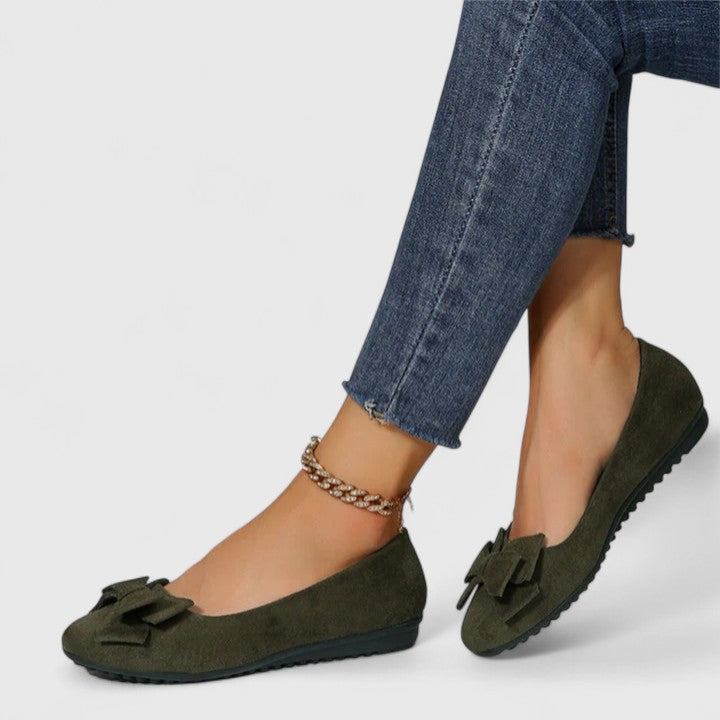 A woman walking easily in dark green classic comfort sandals with a broad, cushioned footbed.