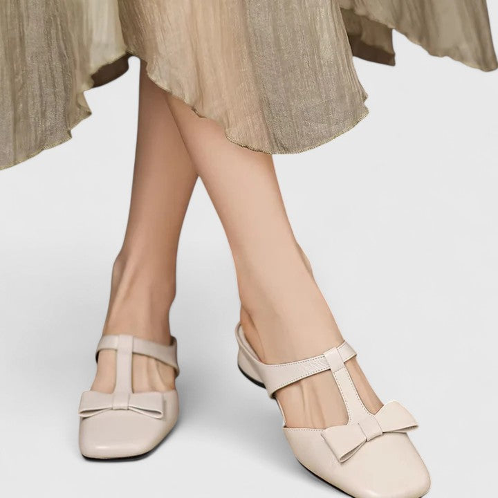 A woman wearing soft pink comfort sandals with a broad, cushioned footbed on a sunny day.