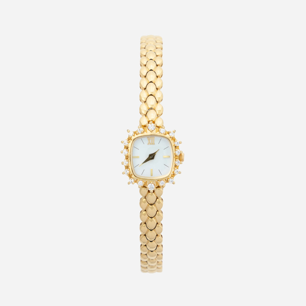 Slim women's bracelet watch with a vibrant colour detail against a simple light dial