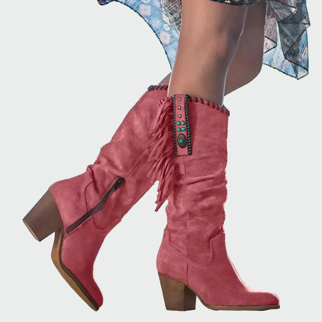 Woman wearing fringed boho-Western ankle boots with a floaty dress at a festival.