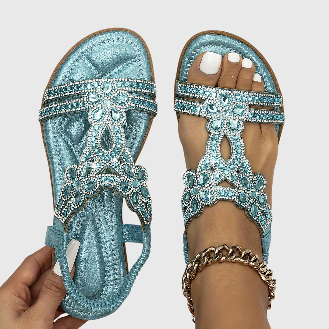A woman wearing elegant gold open-front sandals with supportive straps and a cushioned sole.