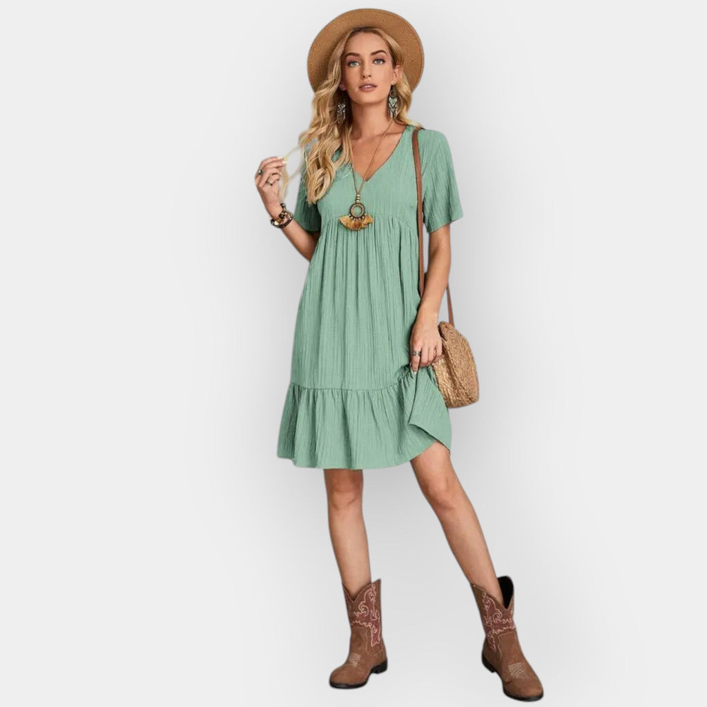 Fluid V-neck midi dress in soft sage green with a relaxed elegant silhouette