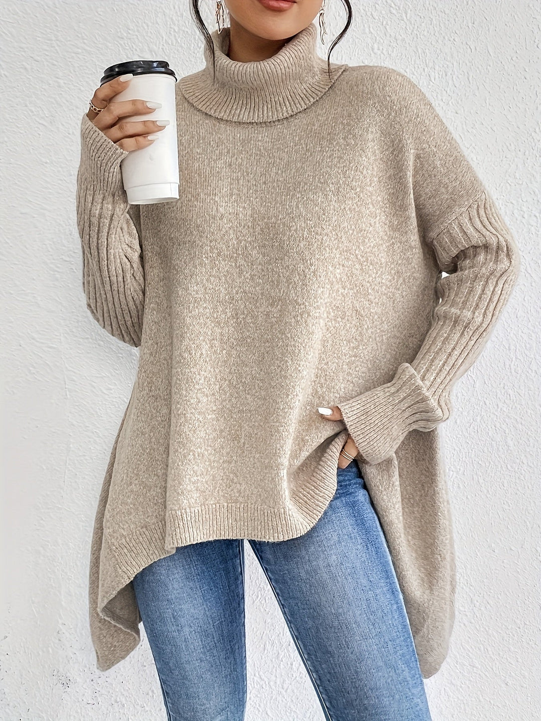 A woman wearing a stand-collar jumper with a chic asymmetric drape, warm and polished.