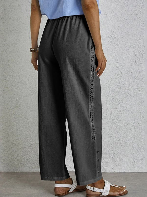 Woman wearing relaxed button-detail trousers with a simple top, out for the day.