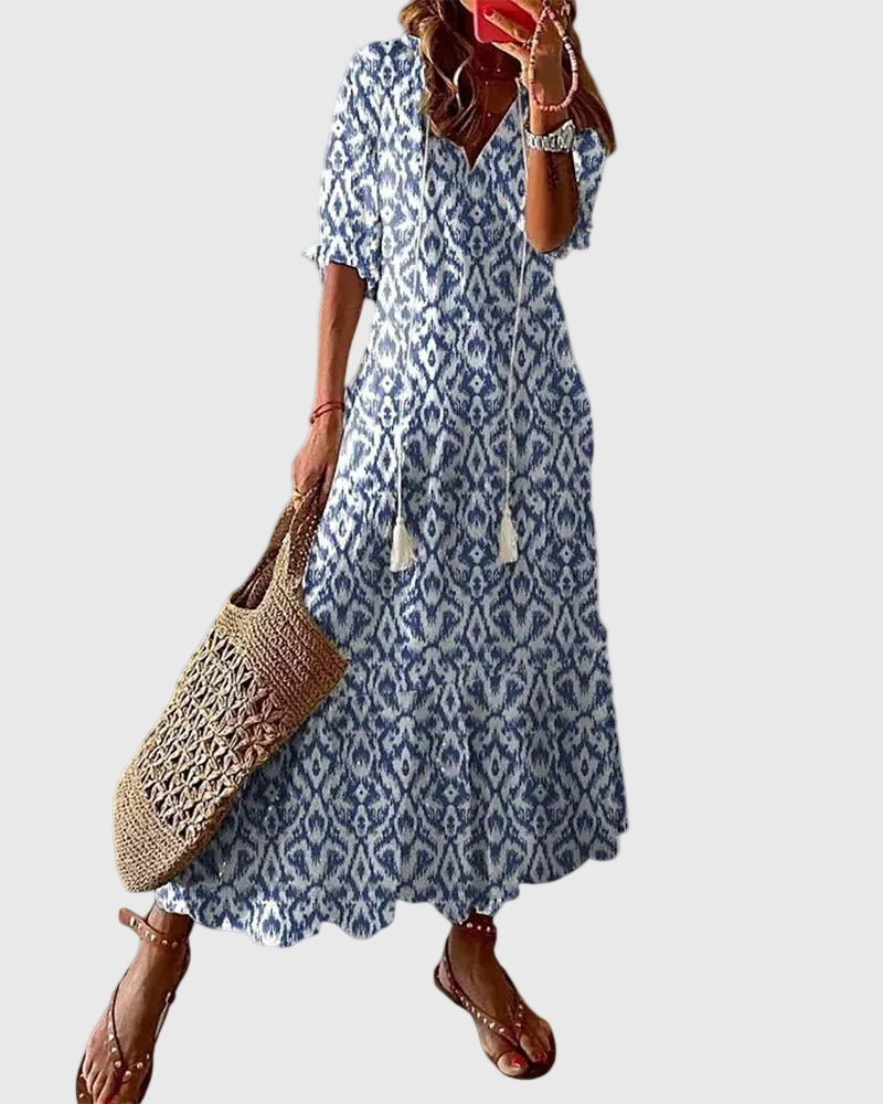 Woman wearing a long vintage-style boho maxi dress with delicate patterns and a fluttering V-neckline.