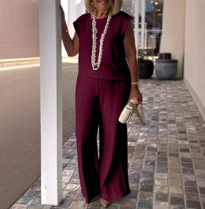 A woman wearing a flowing short-sleeve top with graceful wide-leg trousers.