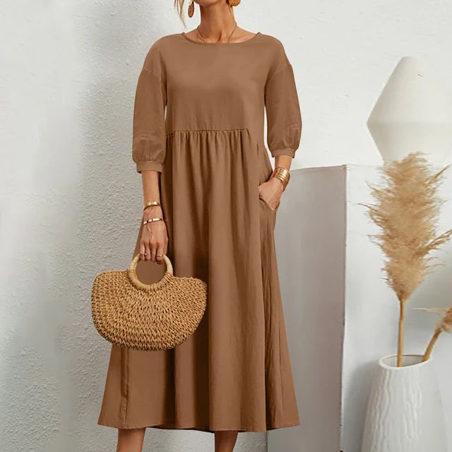 A woman wearing the Sheila fitted waist midi dress with three-quarter sleeves and a flowing skirt.