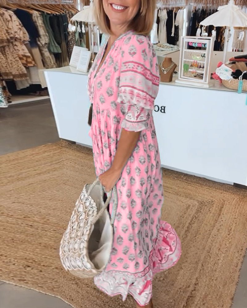 A woman wearing the Patricia boho floral midi dress with a fringed neckline and ruffled skirt.