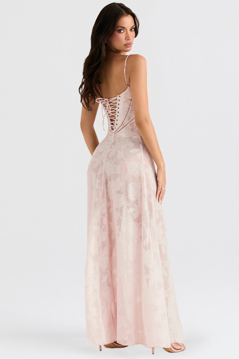 An elegant floor-length occasion dress in blush pink, styled for a formal wedding or gala event