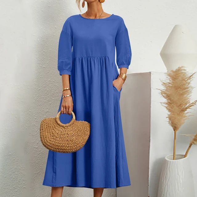 A woman wearing the Sheila fitted waist midi dress with three-quarter sleeves and a flowing skirt.