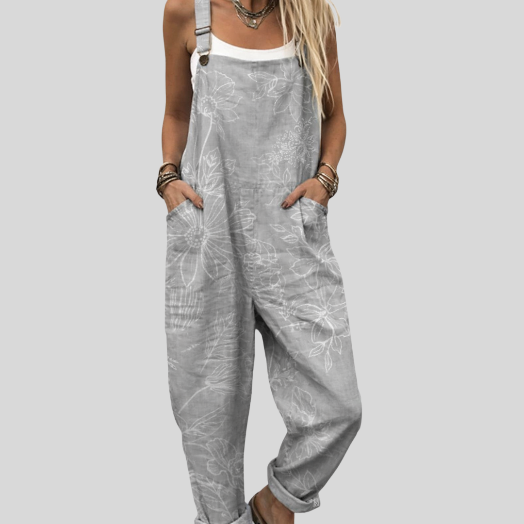 Woman wearing the Clodagh™ light grey harem-leg dungarees with a subtle, washed all-over skull print across the bib and legs.