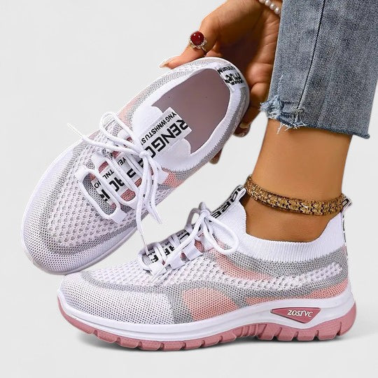 A woman lacing up light, breathable orthopaedic trainers before a walk.