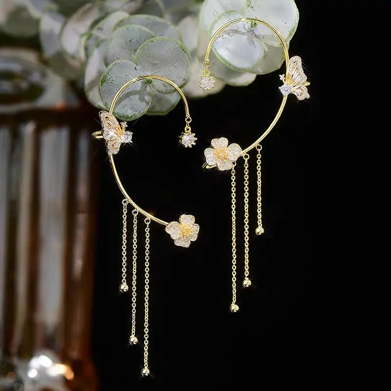 Gold celestial arc earring with a butterfly detail, framing the ear with sparkling luminosity