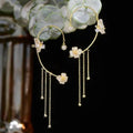 Gold celestial arc earring with a butterfly detail, framing the ear with sparkling luminosity
