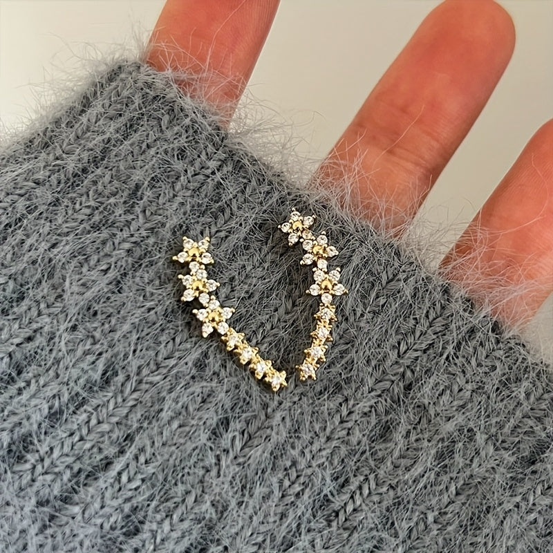 Rose gold floral crawler earrings with delicate sparkling floral motif following the curve of the ear