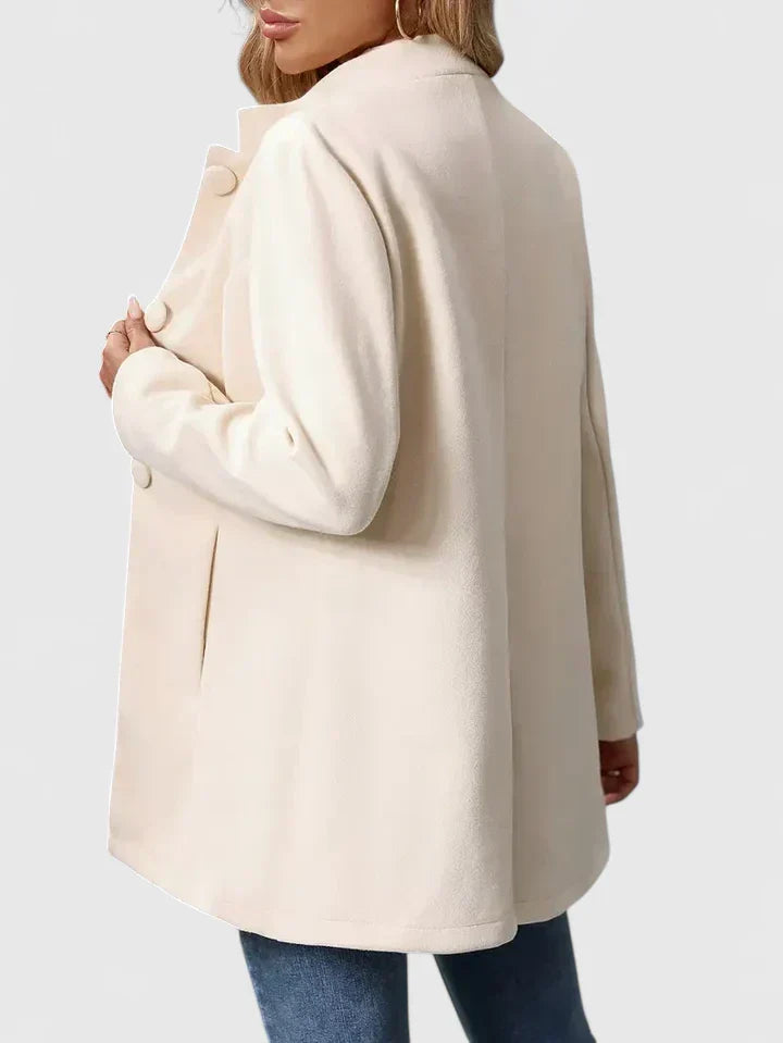 A woman wearing a collarless tailored jacket with a button front