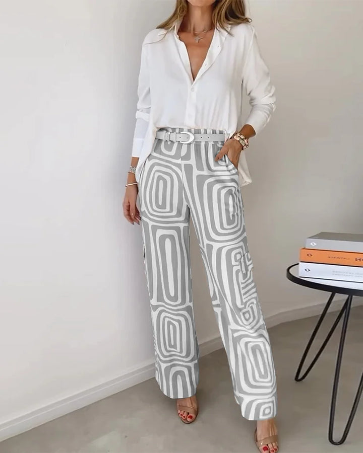 A woman wearing a geometric-print top and trousers set with a matching belt at the waist.