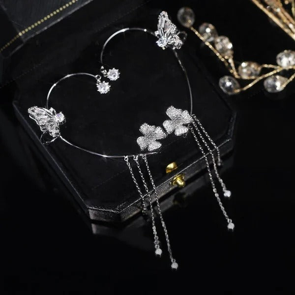 Gold celestial arc earring with a butterfly detail, framing the ear with sparkling luminosity