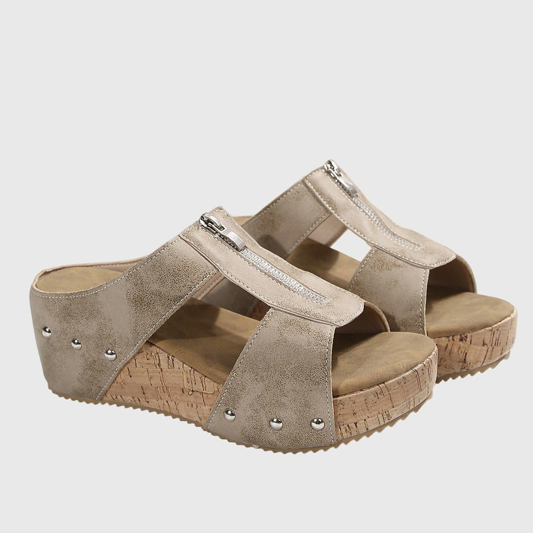 A woman standing comfortably in brown supportive sandals with an adjustable strap and cushioned sole.