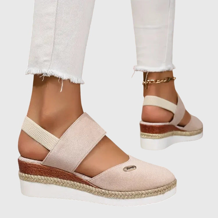 A woman walking comfortably in black cushioned support sandals with adjustable straps.