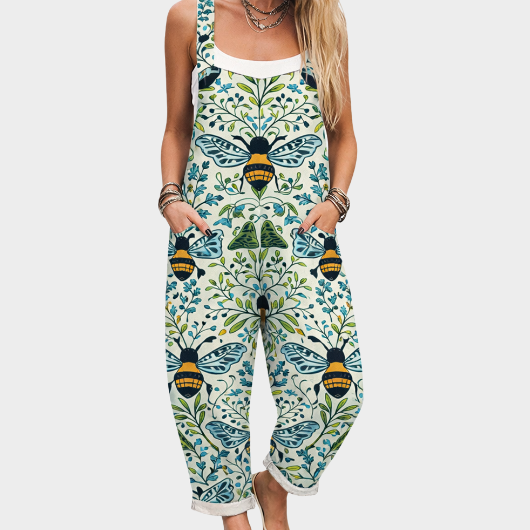 A woman wearing relaxed bee-and-vine print dungarees with adjustable straps on a warm day.