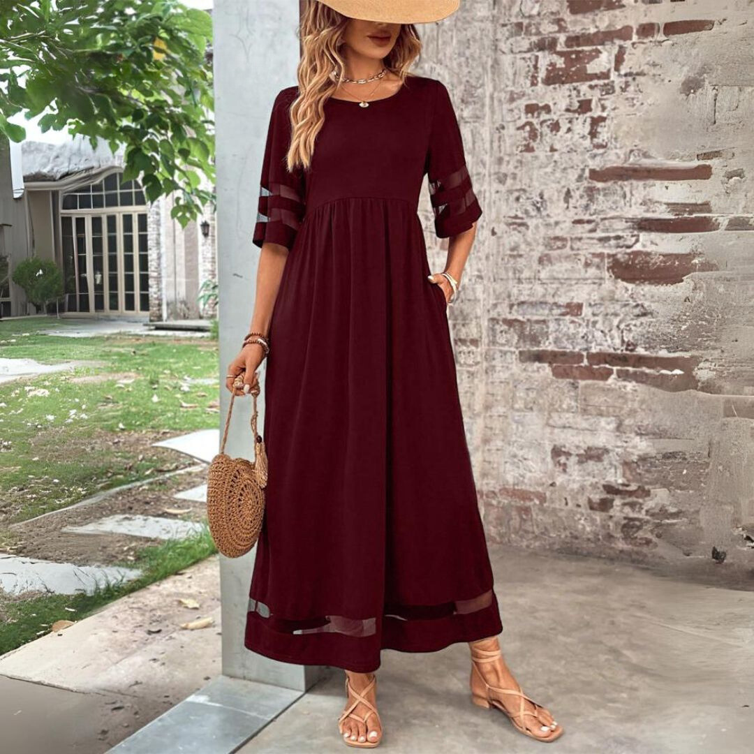 Woman wearing the Winifred™ empire waist midi dress with a flowing skirt and round neckline at a family gathering.