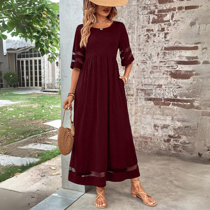 Woman wearing the Winifred™ empire waist midi dress with a flowing skirt and round neckline at a family gathering.
