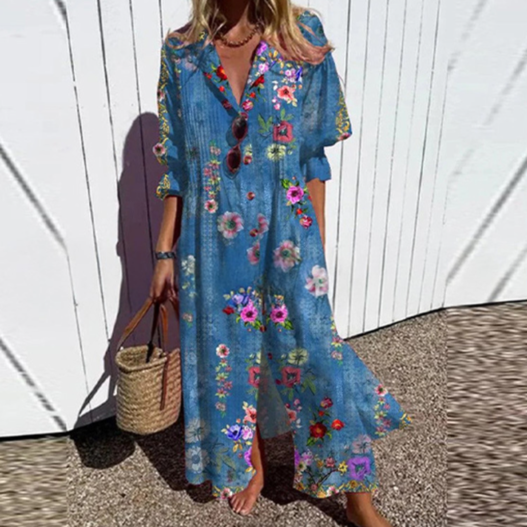 Woman wearing the Zara™ leaf print maxi dress with a button front, walking along the coast in a light breeze.