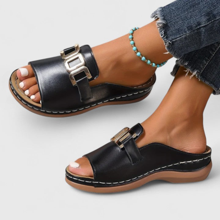 A woman walking easily in grey supportive sandals with a cushioned sole and adjustable strap.