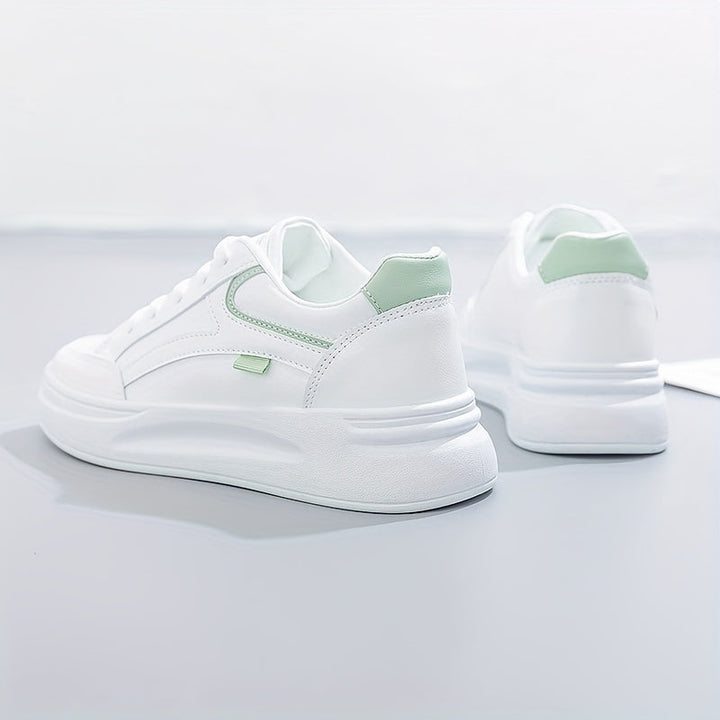 A woman in crisp white light comfort trainers paired with jeans.