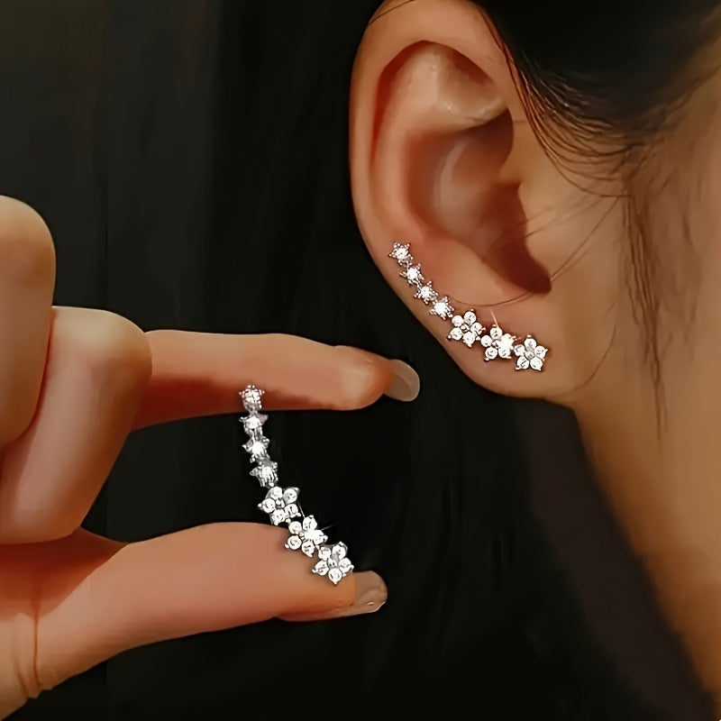 Rose gold floral crawler earrings with delicate sparkling floral motif following the curve of the ear