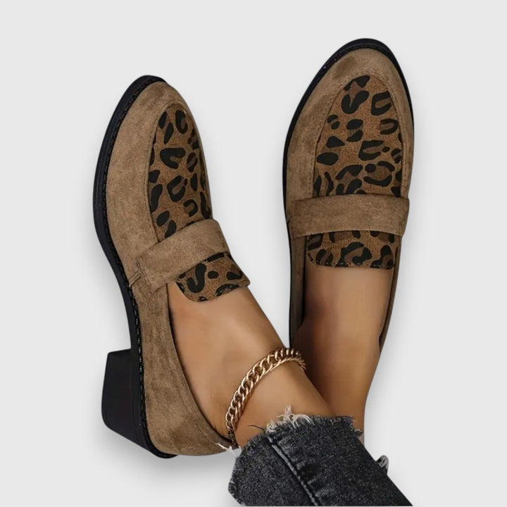 A woman wearing soft grey house slippers, relaxing comfortably at home.