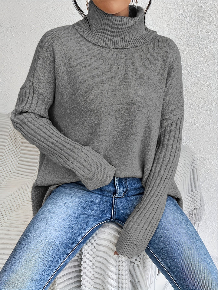 A woman wearing a stand-collar jumper with a chic asymmetric drape, warm and polished.