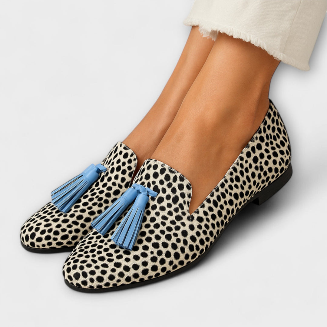 A woman wearing slip-on loafers with decorative fringing, styled for an easy everyday look.