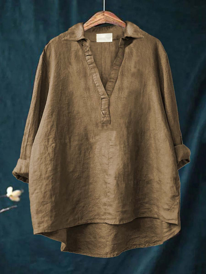 A woman wearing an elegant solid-colour summer blouse with an open V-neck, looking fresh and stylish on a warm day.