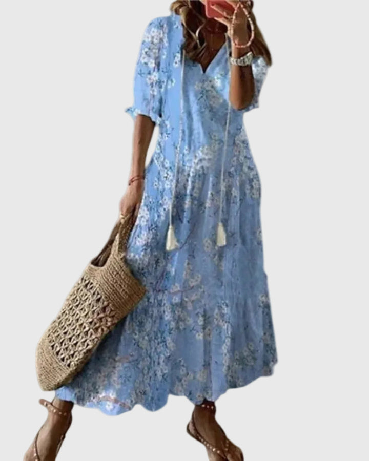Woman wearing a long vintage-style boho maxi dress with delicate patterns and a fluttering V-neckline.